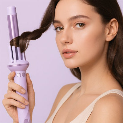 Belle femme tient un boucleur automatique violet