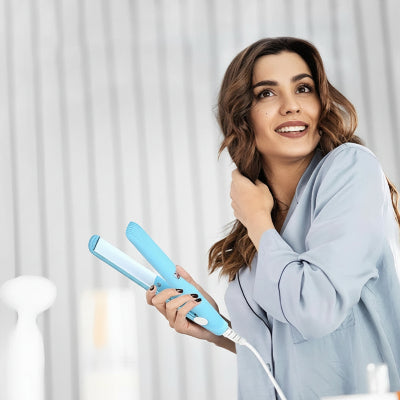 belle femme tient lisseur à cheveux