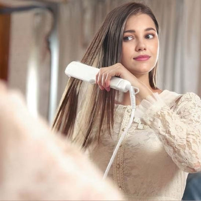 femme avec ses longs cheveux utilise lisseur cheveux